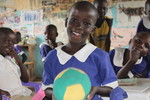 Smiling girl in child-friendly classroom supported by Plan